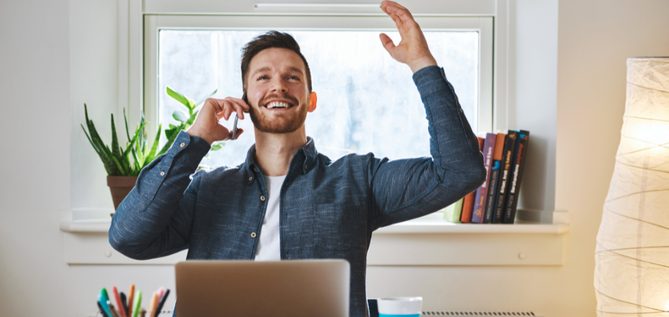 man at desk experiencing success
